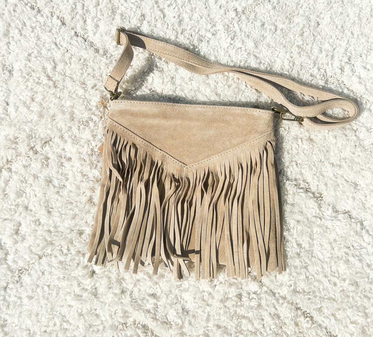 Le sac à franges avec sa bandoulière réglable de couleur écru